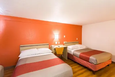 a motel room with two beds and a desk at Travelodge by Wyndham Essington / Philadelphia Airport in Essington
