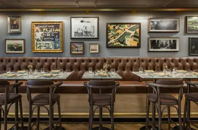 a restaurant with tables and chairs and pictures on the wall at Merrion Row Hotel and Public House in New York