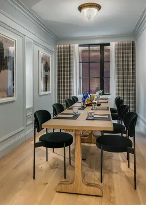 a conference room with a wooden table and chairs at Merrion Row Hotel and Public House in New York