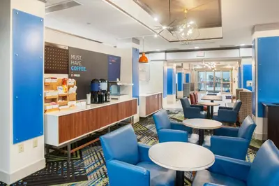 a restaurant with blue chairs and tables and a counter at Holiday Inn Express and Suites Stroudsburg-Poconos by IHG in Stroudsburg