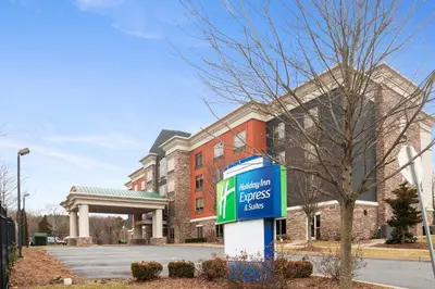 a sign in front of a large brick building at Holiday Inn Express and Suites Stroudsburg-Poconos by IHG in Stroudsburg