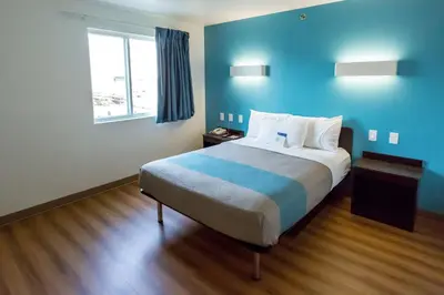 a bedroom with a bed with blue walls and a window at Motel 6-Pottstown, PA in Pottstown