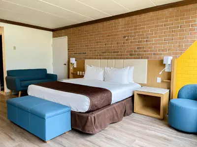 a hotel room with a bed and two chairs at Split Rock Resort in Lake Harmony