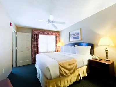 a bedroom with a large white bed with a ceiling fan at Split Rock Resort in Lake Harmony