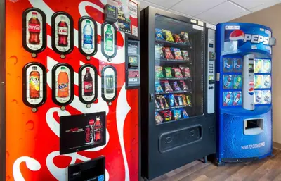 a soda machine is next to a soda cooler at Extended Stay America Suites - Secaucus - New York City Area in Secaucus