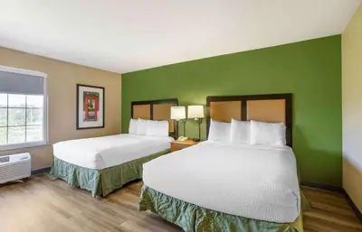 two beds in a hotel room with green walls at Extended Stay America Suites - Meadowlands - East Rutherford in East Rutherford