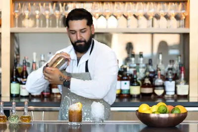 a man standing behind a bar preparing a drink at The MC, Autograph Collection in Montclair