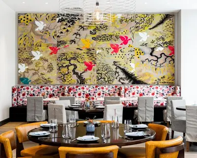 a dining room with tables and chairs and a large painting at The MC, Autograph Collection in Montclair