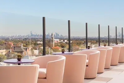 a row of chairs and tables with a view of the city at The MC, Autograph Collection in Montclair