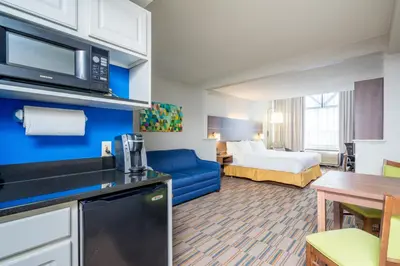 a hotel room with a king sized bed and a kitchen at Holiday Inn Express and Suites Quakertown - Allentown Area by IHG in Quakertown