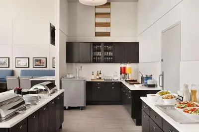 a large kitchen with black cabinets and white appliances at Homewood Suites University City Philadelphia in Philadelphia