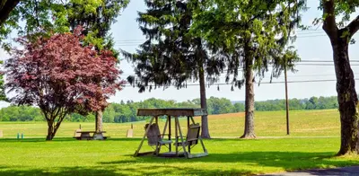 a swing set in a park with trees at Motel 6-Shartlesville, PA in Shartlesville