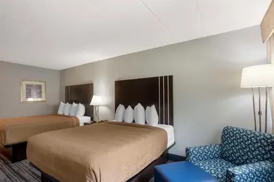 a hotel room with two beds and a chair at Best Western Plus Reading Inn & Suites in Reading