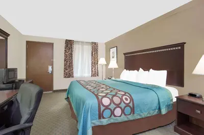 a hotel room with a bed and a desk and a television at Super 8 by Wyndham Danville in Danville