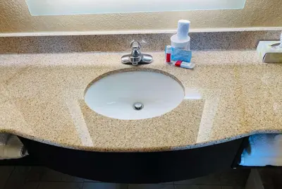 a bathroom counter with a sink with a bottle of soap at Super 8 by Wyndham Danville in Danville