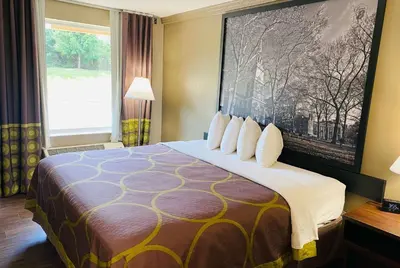 a hotel room with a bed with a large window at Super 8 by Wyndham Danville in Danville