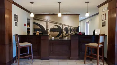a bar with two chairs and a painting on the wall at Staybridge Suites East Stroudsburg - Poconos by IHG in East Stroudsburg