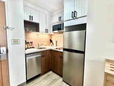 a kitchen with wooden cabinets and a stainless steel refrigerator at Staybridge Suites East Stroudsburg - Poconos by IHG in East Stroudsburg
