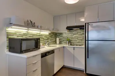 a kitchen with white cabinets and a stainless steel refrigerator at Element Ewing Princeton in Ewing