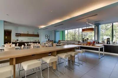 a restaurant with a bar with white stools at Element Ewing Princeton in Ewing