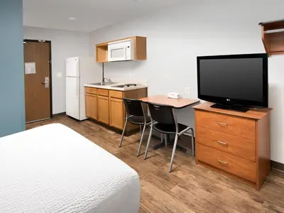a hotel room with a bed and a desk with a television at WoodSpring Suites Allentown Bethlehem in Bethlehem