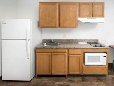 a kitchen with a white refrigerator and a sink at WoodSpring Suites Allentown Bethlehem in Bethlehem