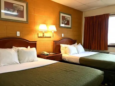 a hotel room with two beds and a window at Red Carpet Inn Duncannon in New Buffalo