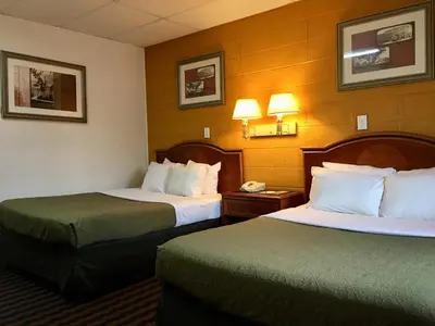 a hotel room with two beds and a phone at Red Carpet Inn Duncannon in New Buffalo