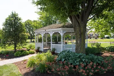 a white gazebo in a garden with flowers at Travelers Rest Motel in Intercourse
