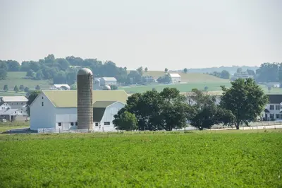 a white barn with a silo in a field at Travelers Rest Motel in Intercourse