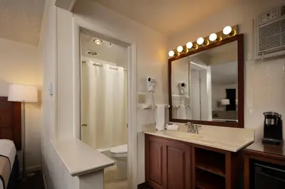 a bathroom with a shower and a sink and a mirror at Travelers Rest Motel in Intercourse