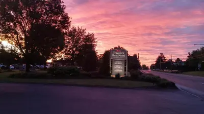 a sign in the middle of a road with a sunset at Travelers Rest Motel in Intercourse