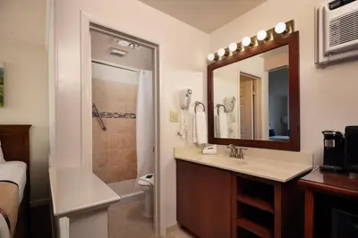 a bathroom with a sink and a shower and a mirror at Travelers Rest Motel in Intercourse