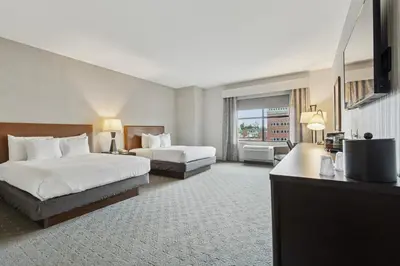 a hotel room with two beds and a television at The Hotel Warner in West Chester