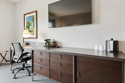 a desk in a room with a chair and a mirror at The Hotel Warner in West Chester