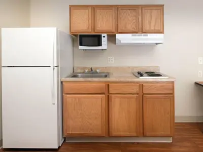 a kitchen with a white refrigerator and a sink at WoodSpring Suites Wilkes-Barre in Wilkes-Barre