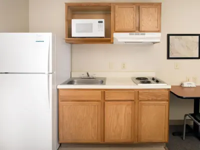 a kitchen with a sink and a white refrigerator at WoodSpring Suites Wilkes-Barre in Wilkes-Barre