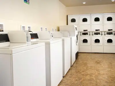 a white laundry room with white washers and dryers at WoodSpring Suites Wilkes-Barre in Wilkes-Barre