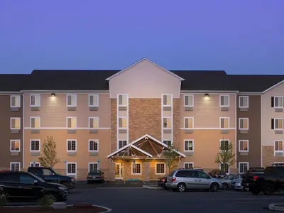 a large apartment building with cars parked in a parking lot at WoodSpring Suites Wilkes-Barre in Wilkes-Barre