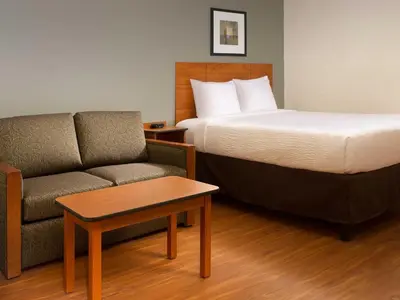 a hotel room with a bed and a couch at WoodSpring Suites Wilkes-Barre in Wilkes-Barre