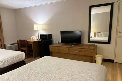 a hotel room with two beds and a flat screen tv at Days Inn by Wyndham Williamsport in Williamsport