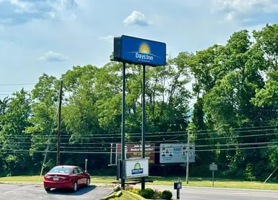 a sign for a gas station with a car in a parking lot at Days Inn by Wyndham Williamsport in Williamsport