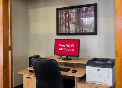an office with a desk with a computer with a sign that reads fire wifi all at Days Inn by Wyndham Williamsport in Williamsport