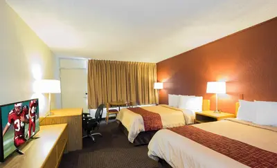 a hotel room with two beds and a flat screen tv at Days Inn by Wyndham Williamsport in Williamsport