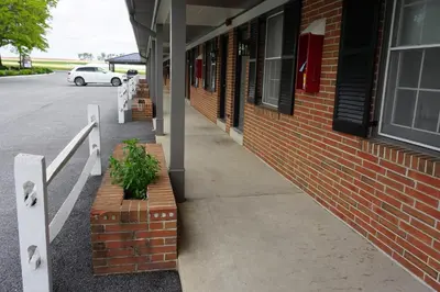 a brick building with a potted plant on the sidewalk at Harvest Drive Family Inn - Renovated Rooms in Gordonville