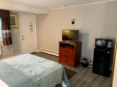 a bedroom with a bed and a television on a dresser at Hill Top Motel in Wrightstown