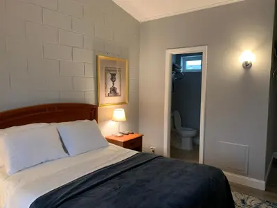 a bedroom with a bed and a bathroom with a toilet at Hill Top Motel in Wrightstown
