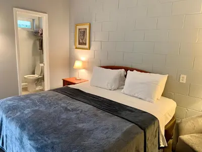 a bedroom with a large bed with two pillows at Hill Top Motel in Wrightstown