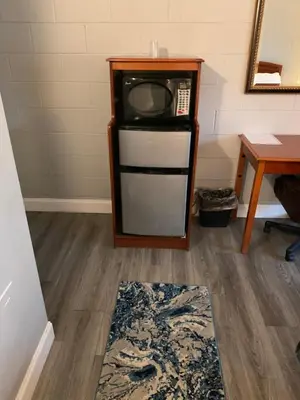 a room with a small refrigerator and a table at Hill Top Motel in Wrightstown