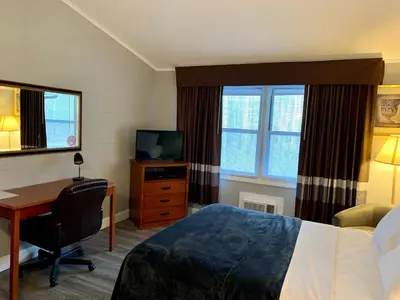 a hotel room with a bed and a desk and a television at Hill Top Motel in Wrightstown